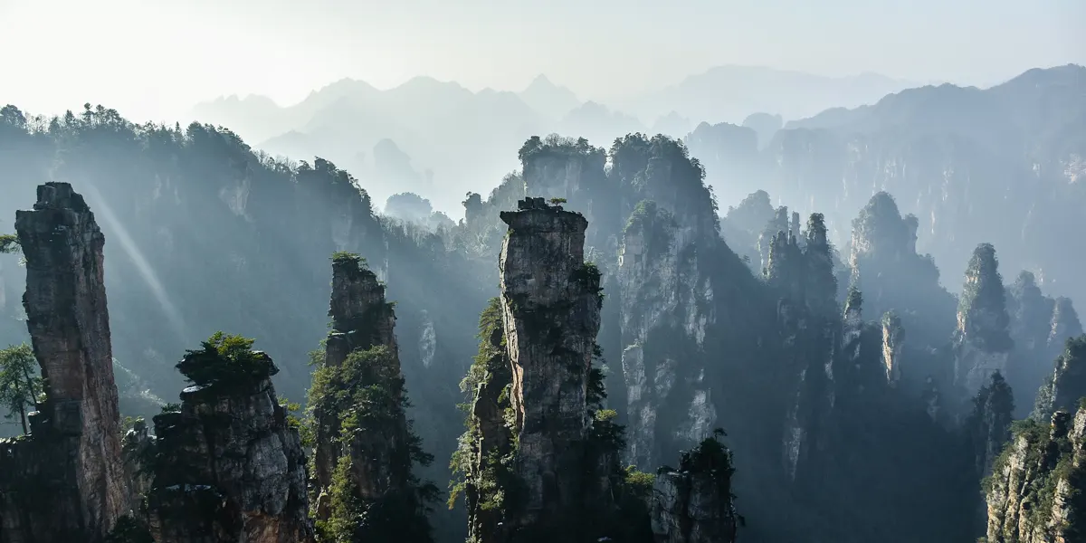 Pilares de arenito sobre um vale com névoa em Zhangjiajie, Hunan