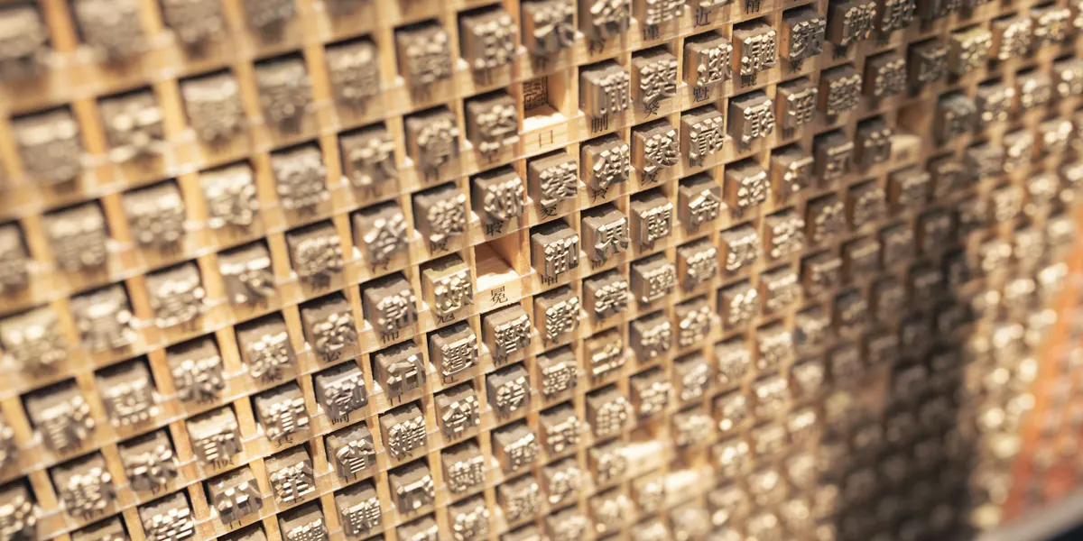 漢字が浮き彫りになった活字ブロックの壁