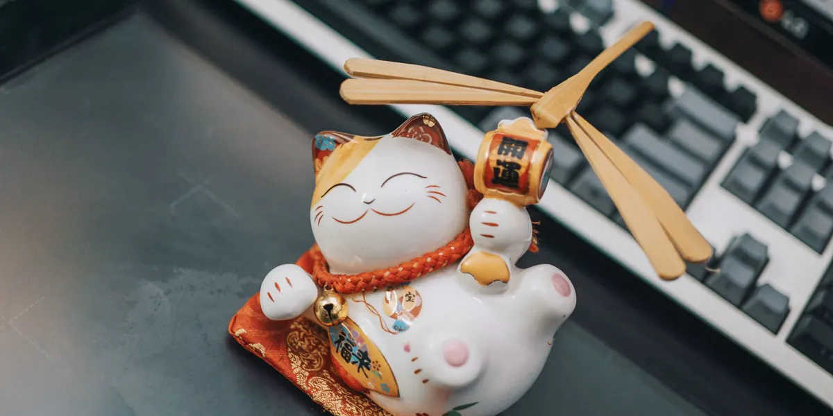 キーボードの横に置かれた陶器の招き猫